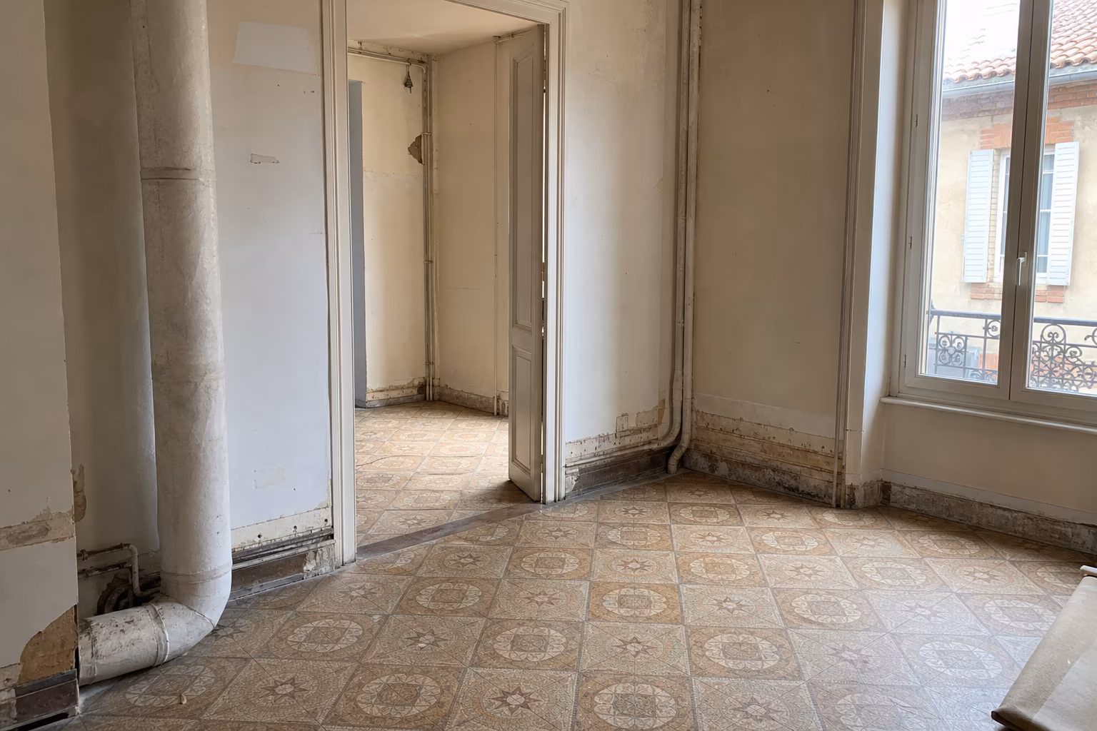 Intérieur d'une maison ancienne en rénovation avec dalles de sol vinyle et conduits susceptibles de contenir de l'amiante